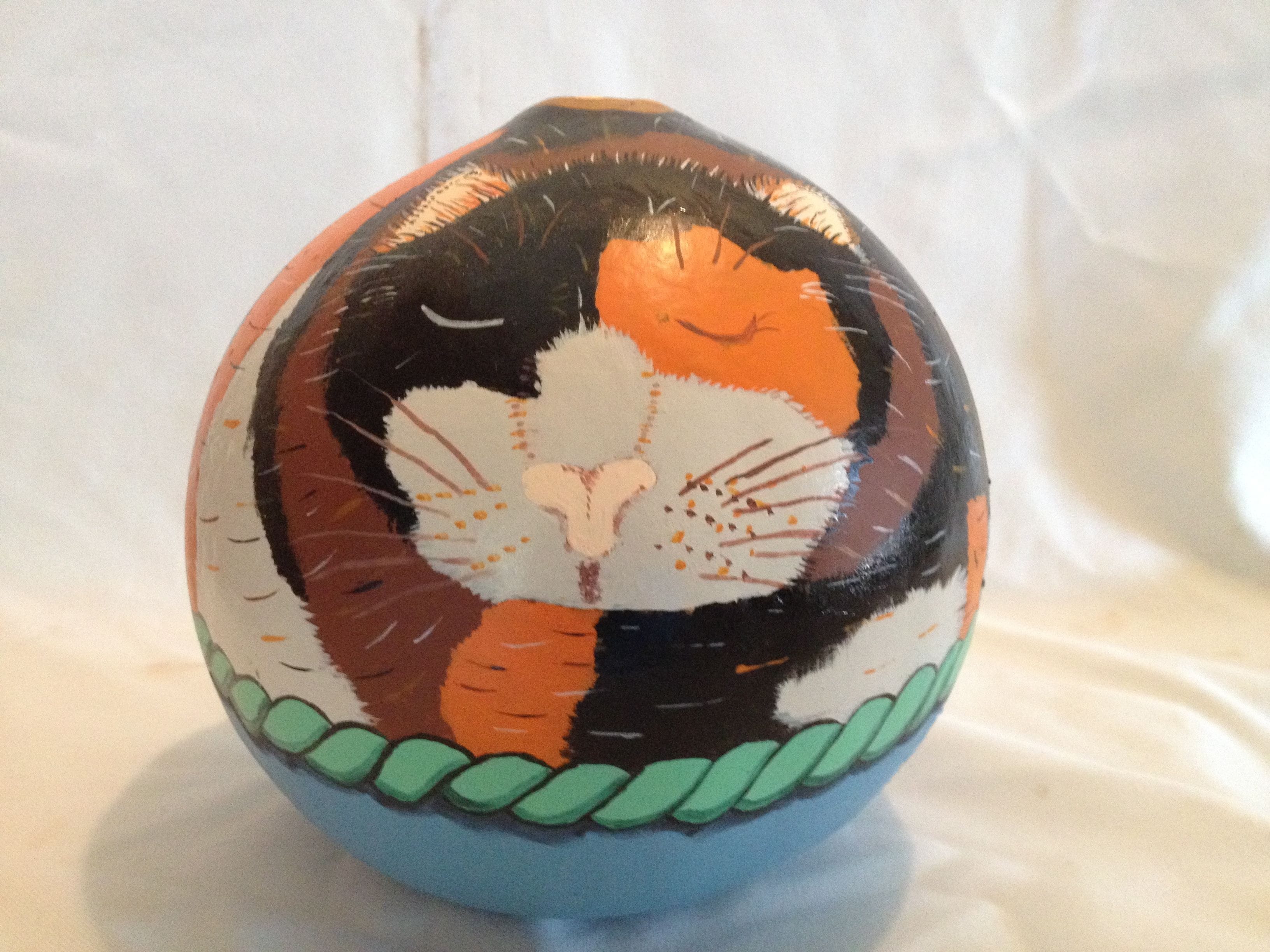Calico cat curled up in basket.$25.