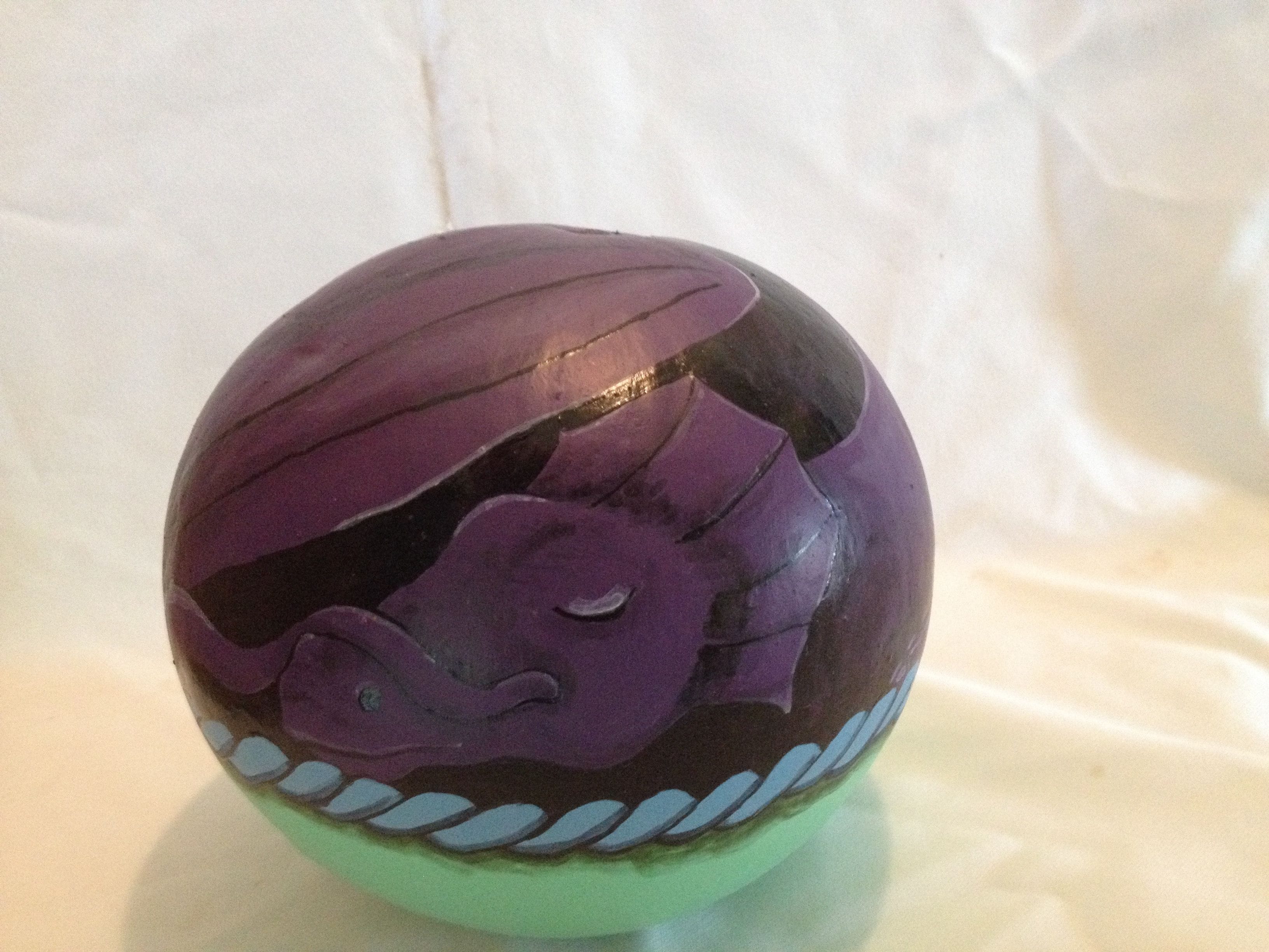 Curled up purple dragon in basket. $25.